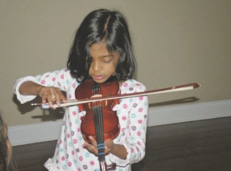 Nadia Priyam playing violin as a child